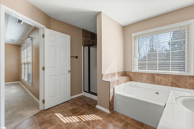 bathroom featuring a textured ceiling, tile patterned flooring, visible vents, a bath, and a stall shower