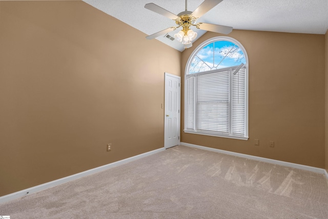 spare room with light colored carpet, visible vents, vaulted ceiling, and baseboards