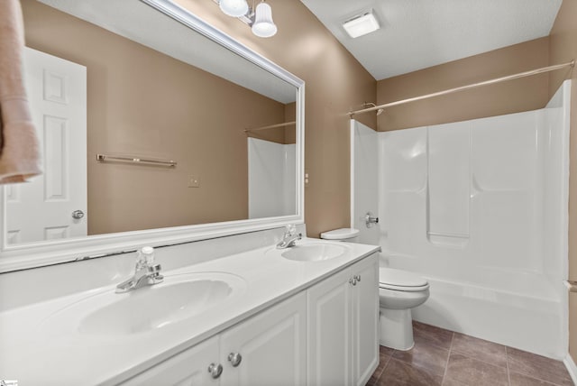 full bathroom with double vanity, tile patterned flooring, a sink, and toilet