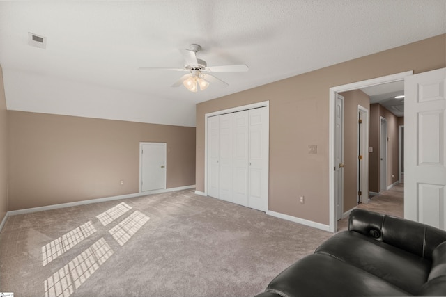 interior space featuring visible vents, light carpet, ceiling fan, a textured ceiling, and baseboards