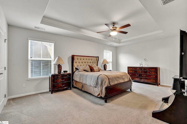 bedroom featuring a tray ceiling, carpet flooring, visible vents, and baseboards