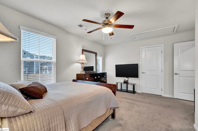 bedroom with visible vents, multiple windows, carpet flooring, and attic access