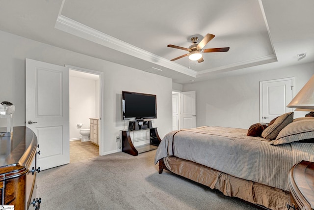 bedroom with baseboards, a raised ceiling, light colored carpet, ornamental molding, and ensuite bathroom