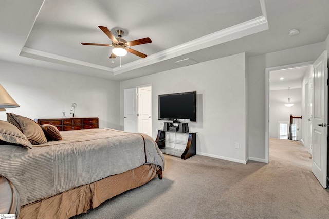 carpeted bedroom featuring a ceiling fan, baseboards, a raised ceiling, and crown molding