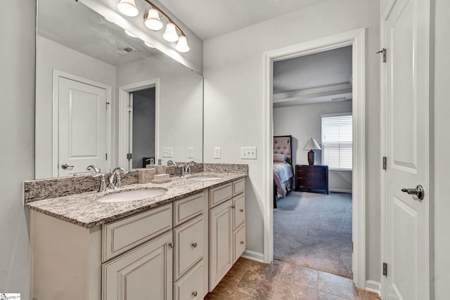 ensuite bathroom featuring connected bathroom, visible vents, a sink, and double vanity