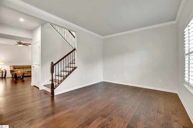 empty room featuring baseboards, stairway, dark wood-style flooring, and crown molding