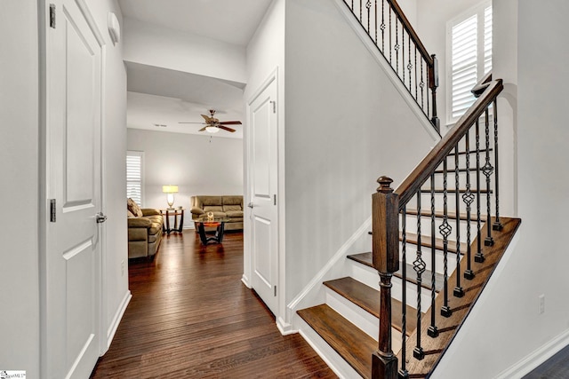 staircase with baseboards, a ceiling fan, and wood finished floors