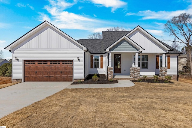 view of front facade with a garage, roof with shingles, concrete driveway, and a front yard