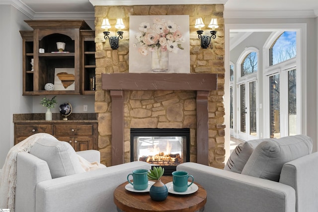 living area with ornamental molding, plenty of natural light, and a fireplace