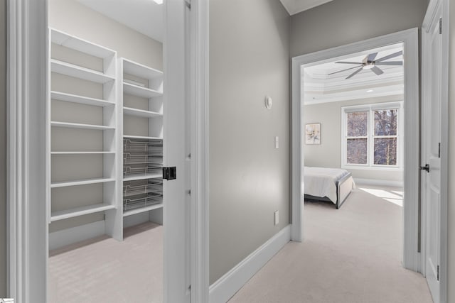 hallway featuring carpet flooring, crown molding, and baseboards