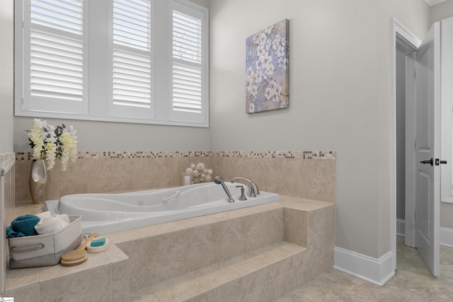 bathroom with baseboards, a bath, and tile patterned floors