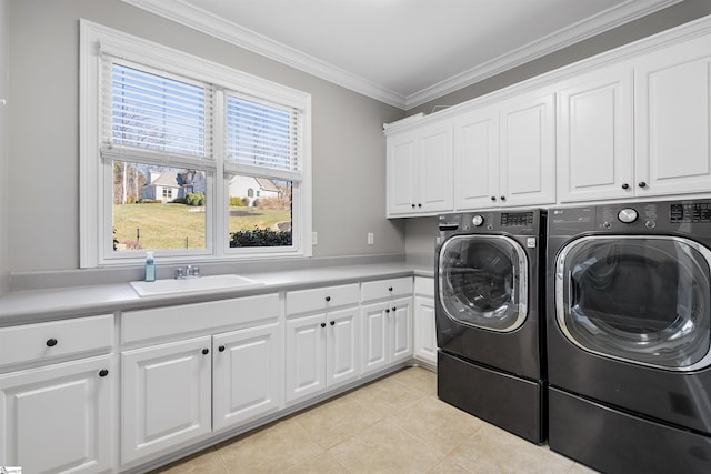 laundry area featuring crown molding, washing machine and clothes dryer, light tile patterned floors, cabinet space, and a sink