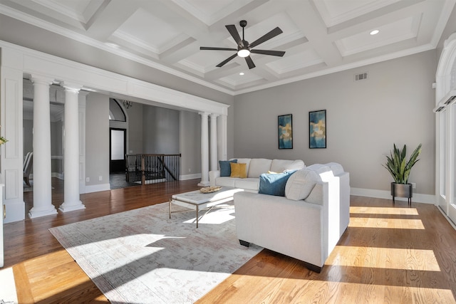 living area with decorative columns, beam ceiling, coffered ceiling, and wood finished floors