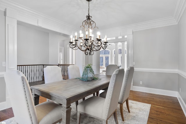 dining area featuring ornamental molding, a notable chandelier, baseboards, and wood finished floors