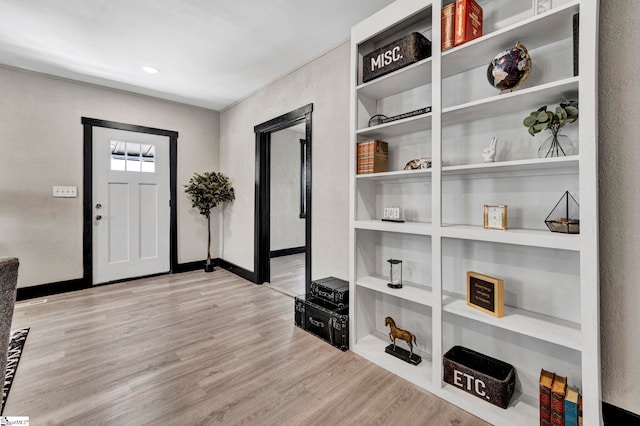 foyer featuring baseboards and wood finished floors