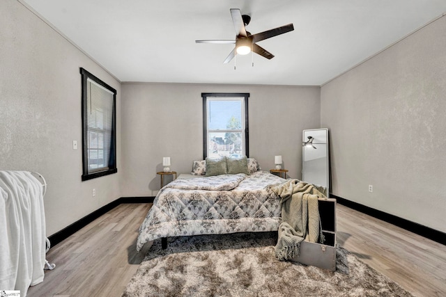 bedroom featuring light wood finished floors, ceiling fan, and baseboards