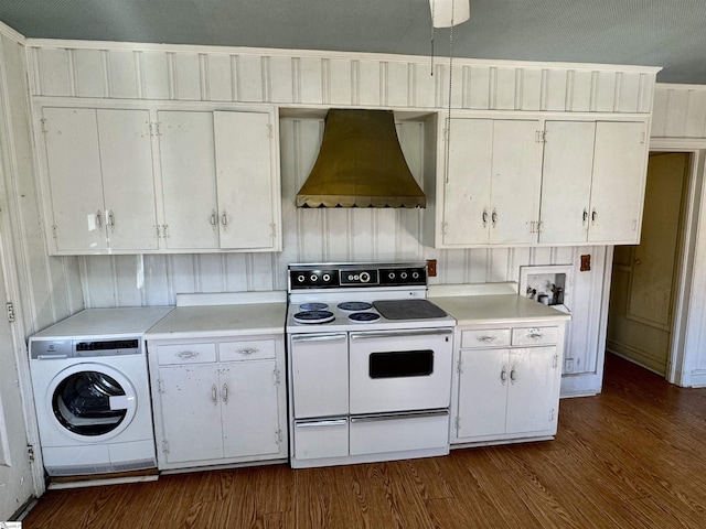 kitchen with dark wood finished floors, range with two ovens, wall chimney exhaust hood, washer / clothes dryer, and light countertops