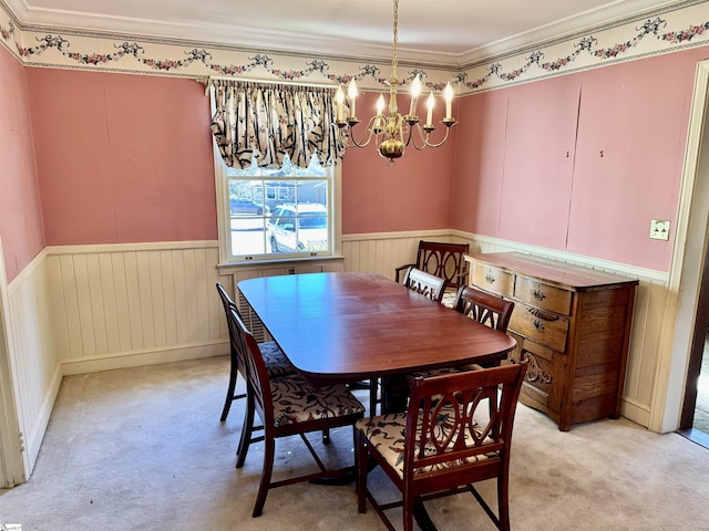 dining space featuring light colored carpet, wainscoting, and crown molding