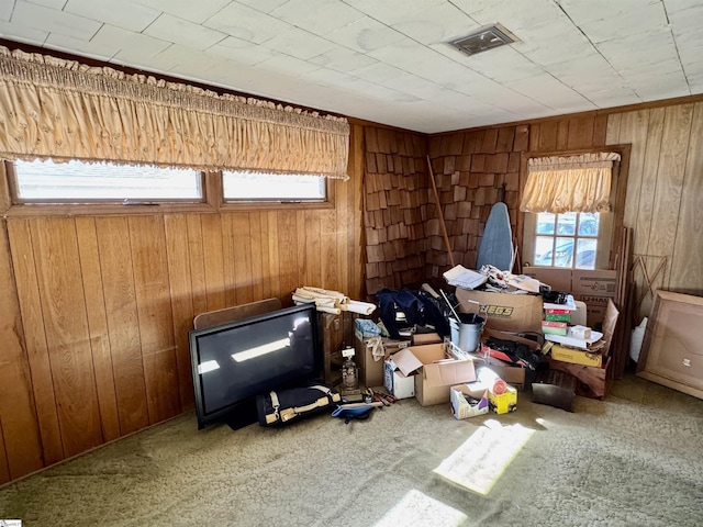 interior space featuring carpet flooring, visible vents, and wooden walls