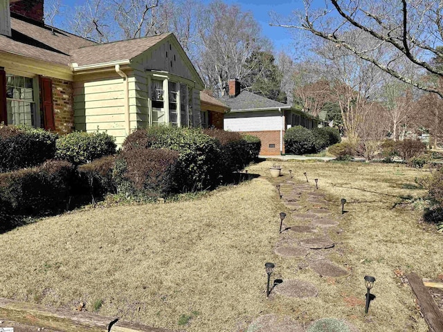 view of property exterior featuring roof with shingles and a chimney