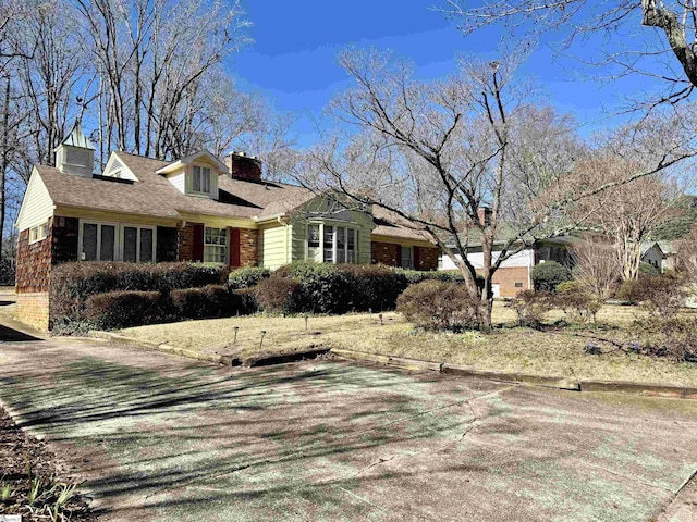 view of property exterior featuring brick siding and a chimney