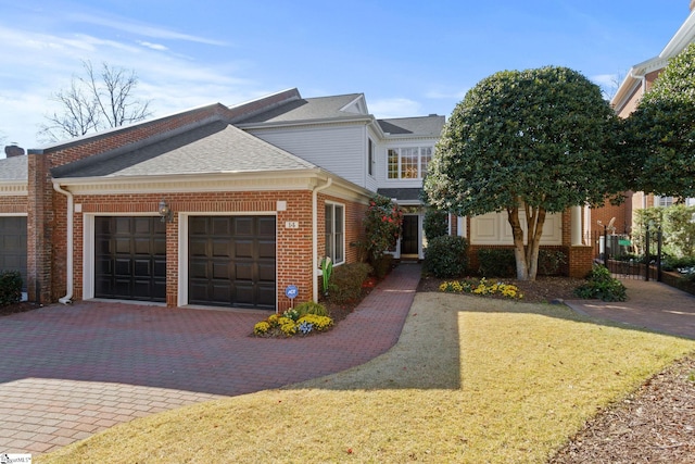 view of front of house with a garage, decorative driveway, brick siding, and a shingled roof