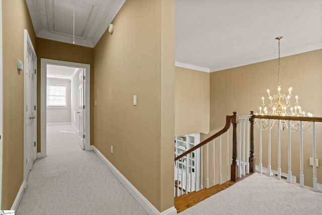 hallway with attic access, ornamental molding, carpet floors, and baseboards