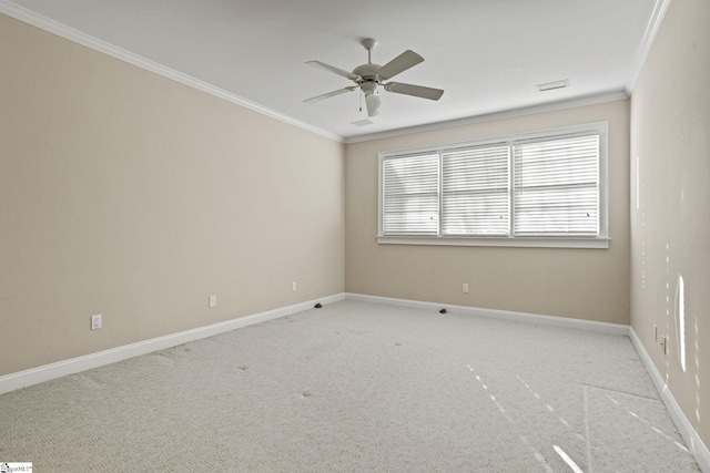 empty room featuring light carpet, visible vents, baseboards, a ceiling fan, and crown molding