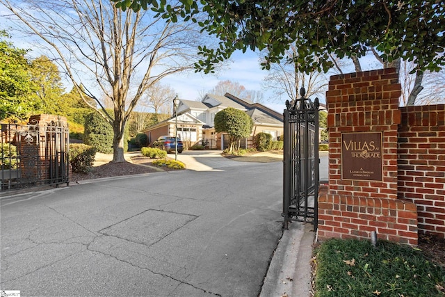 view of road featuring curbs, a gated entry, and a gate