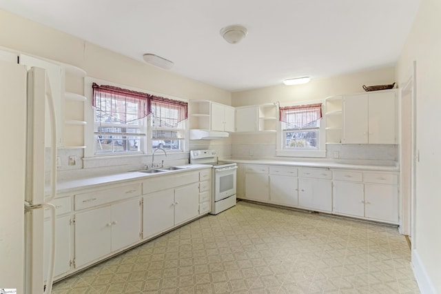 kitchen with white appliances, open shelves, a sink, and light floors