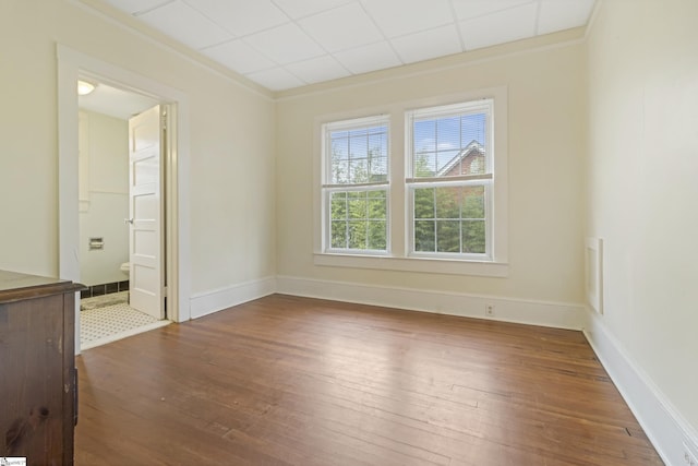 spare room featuring ornamental molding, baseboards, and hardwood / wood-style floors