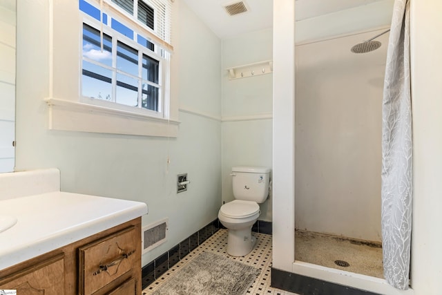 bathroom with a stall shower, visible vents, vanity, and toilet