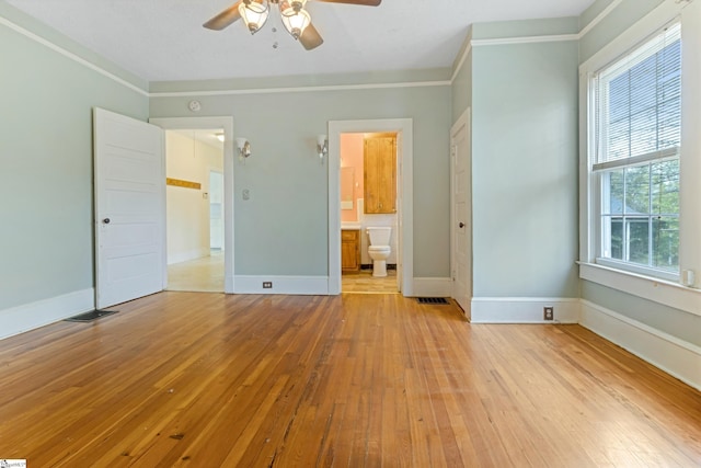 unfurnished bedroom with baseboards, crown molding, visible vents, and light wood finished floors