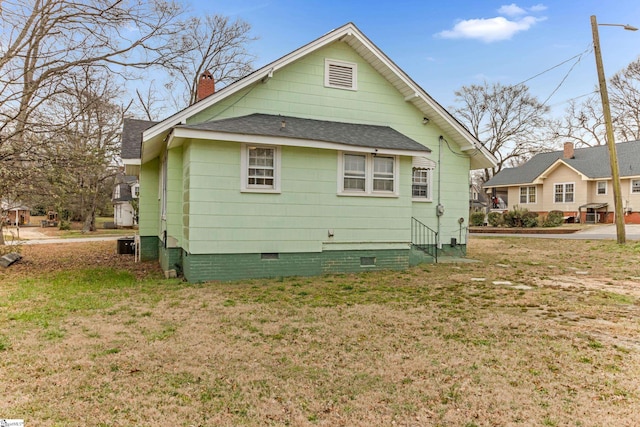 back of property with crawl space, roof with shingles, a lawn, and a chimney