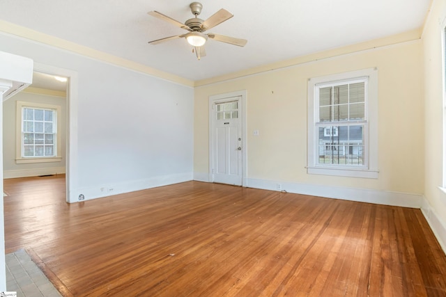 unfurnished room with light wood-type flooring, ceiling fan, baseboards, and a wealth of natural light