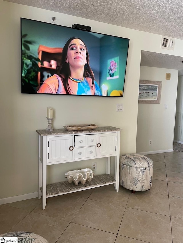 room details featuring a textured ceiling, visible vents, and baseboards