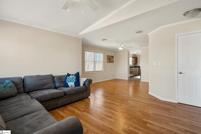 living area with crown molding, baseboards, ceiling fan, and light wood finished floors