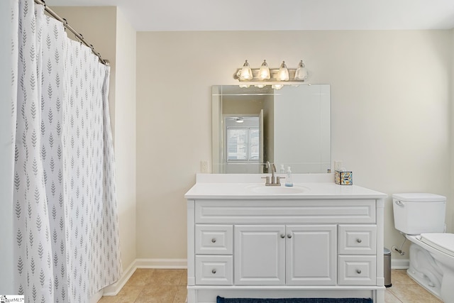 bathroom featuring baseboards, vanity, toilet, and tile patterned floors