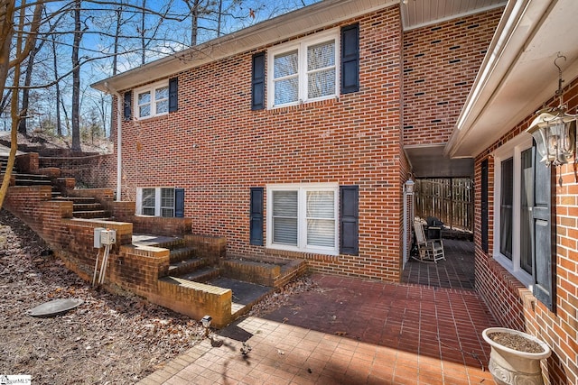 view of property exterior with a patio area and brick siding