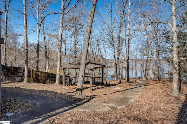 view of yard featuring a gazebo, a water view, and fence