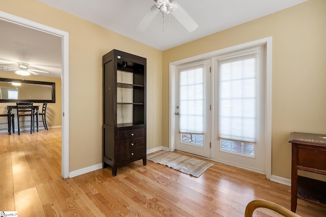 entryway featuring a ceiling fan, baseboards, and light wood finished floors