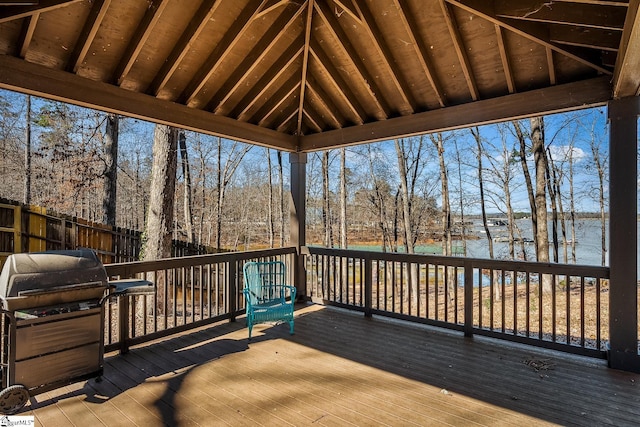 deck with grilling area, fence, and a water view