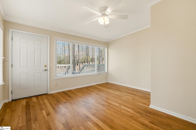 foyer with light wood-style floors, ornamental molding, baseboards, and a ceiling fan