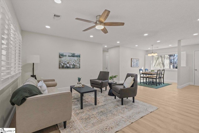 living room with baseboards, visible vents, wood finished floors, and recessed lighting