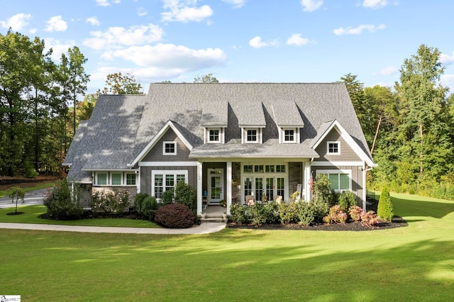 view of front of home with a shingled roof, french doors, and a front lawn