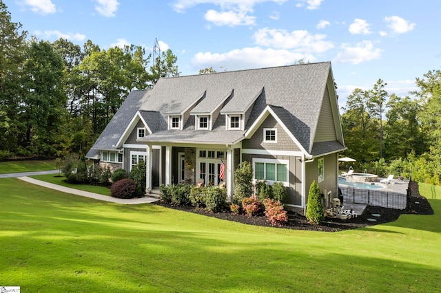 view of front of property with roof with shingles, a front yard, and an outdoor pool