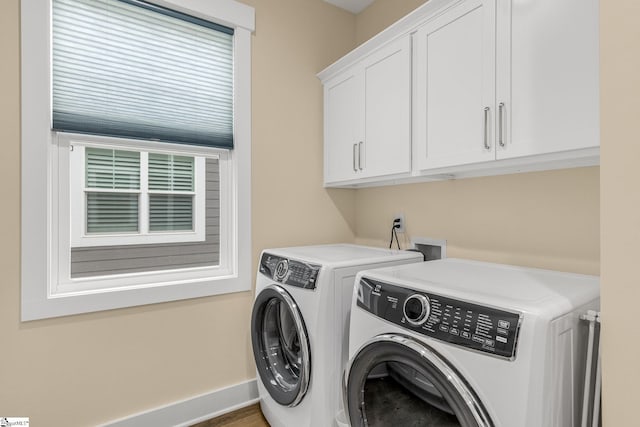 laundry room featuring cabinet space, baseboards, and washing machine and clothes dryer