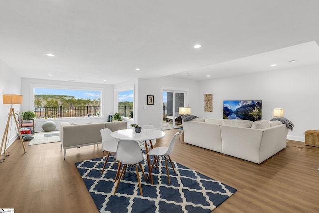 dining room with recessed lighting, a healthy amount of sunlight, baseboards, and wood finished floors