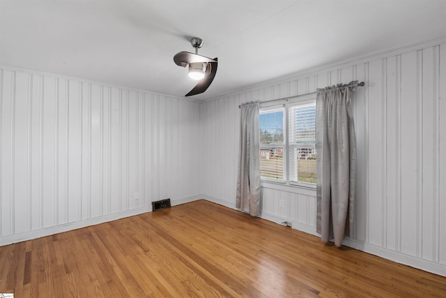 spare room with light wood-style floors and visible vents