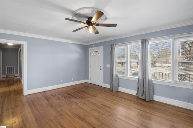 entryway featuring baseboards, visible vents, wood finished floors, and ornamental molding